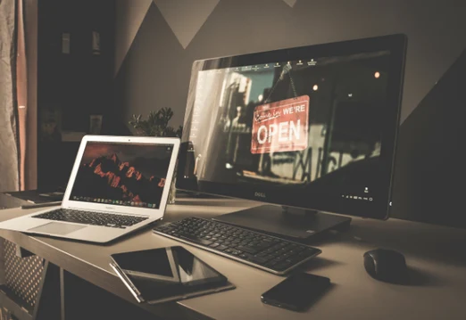Arbeitsplatz mit Desktop und Laptop der ein Webdesign zeigt